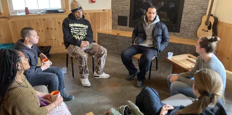 Group of young adults sit in a circle talking